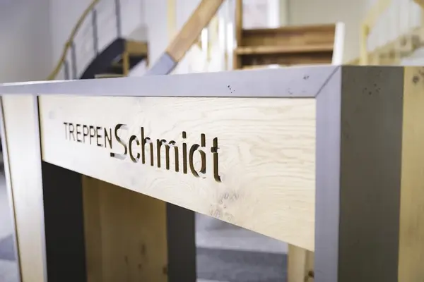 Massive Holztreppe im modernen Design mit gelasertem Firmenlogo Treppen Schmidt.