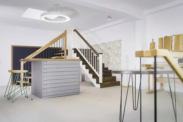 Modernes, helles Treppenhaus mit Holztreppe, Designermöbeln und minimalistischer Einrichtung.