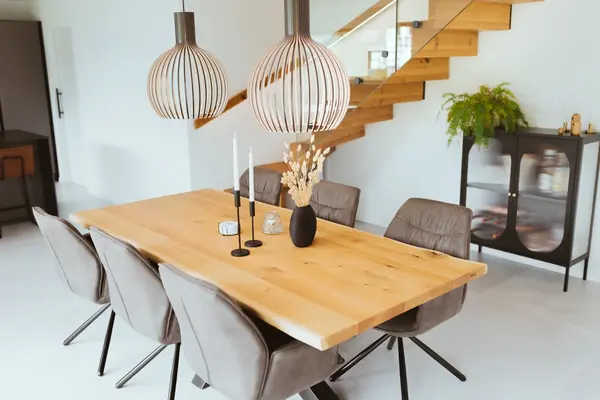 Moderner Essbereich mit Holztisch, Designerstühlen und stilvollen Pendelleuchten.