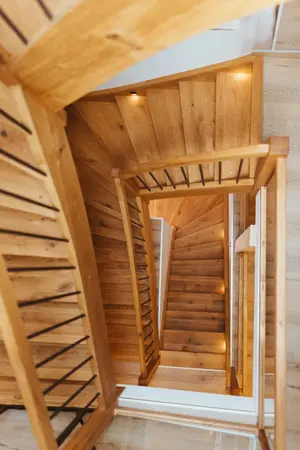 Holztreppe mit modernen Geländern und LED-Beleuchtung in einem hellen Wohnhaus.